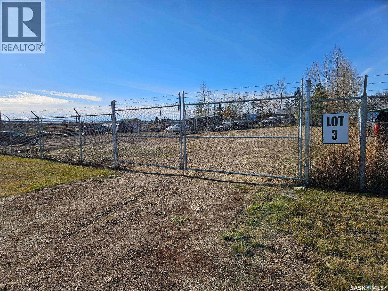 A fenced lot with a sign that says "LOT 3".