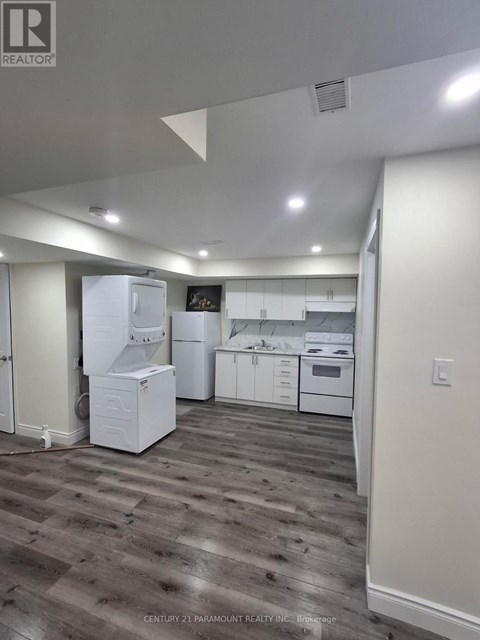 A kitchen with white appliances and wood flooring.