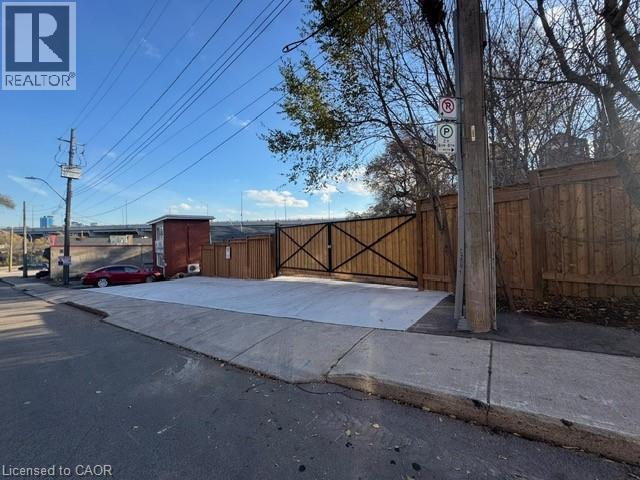 A street view with a red car and a sign that says "REALTOR".