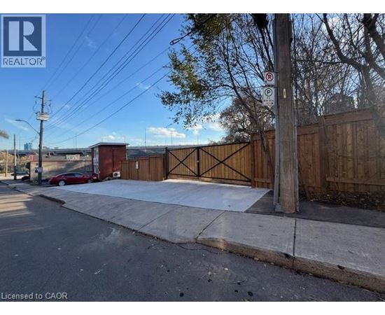 A street view with a red car and a sign that says "REALTOR".