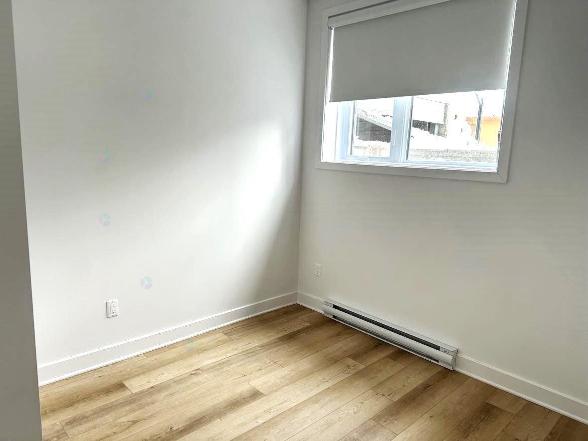 A room with a window and a radiator on the floor.