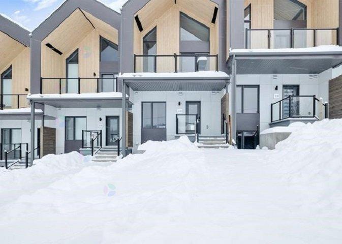 A row of modern houses with snow on the ground.