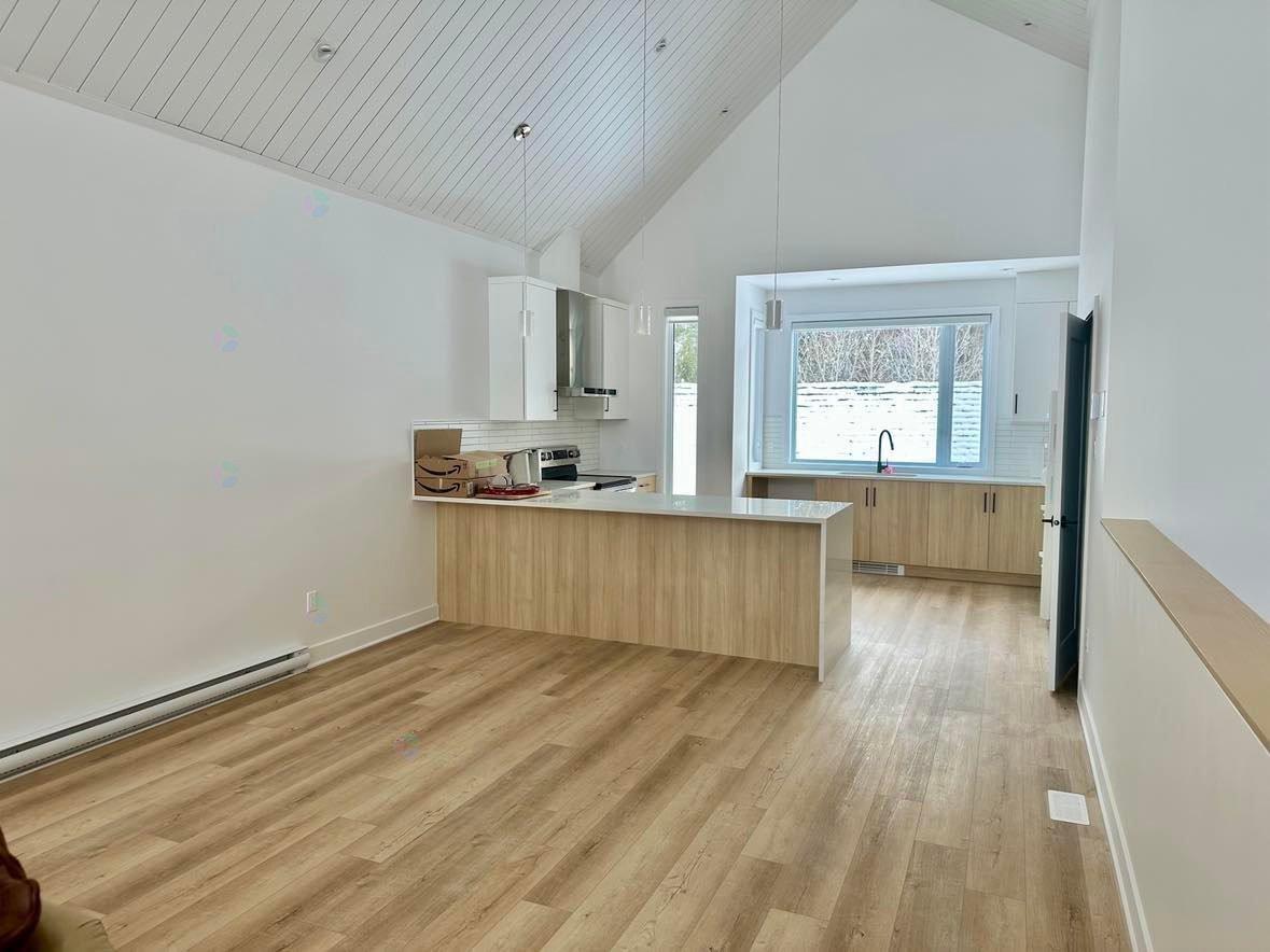 A kitchen with wooden floors and cabinets.