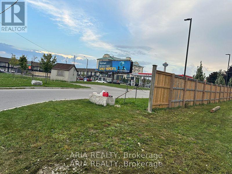 A grassy area with a fence and a sign that says "REALTOR".