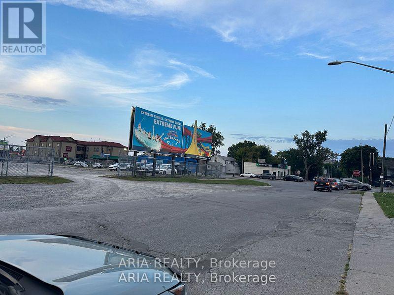 A car is parked in a lot with a billboard in the background.