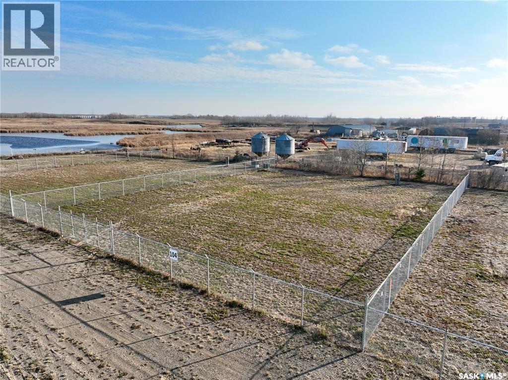 A fenced-off plot of land with a building in the distance.