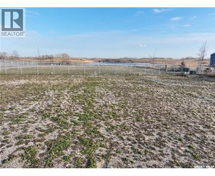 A field with a fence and a body of water in the distance.