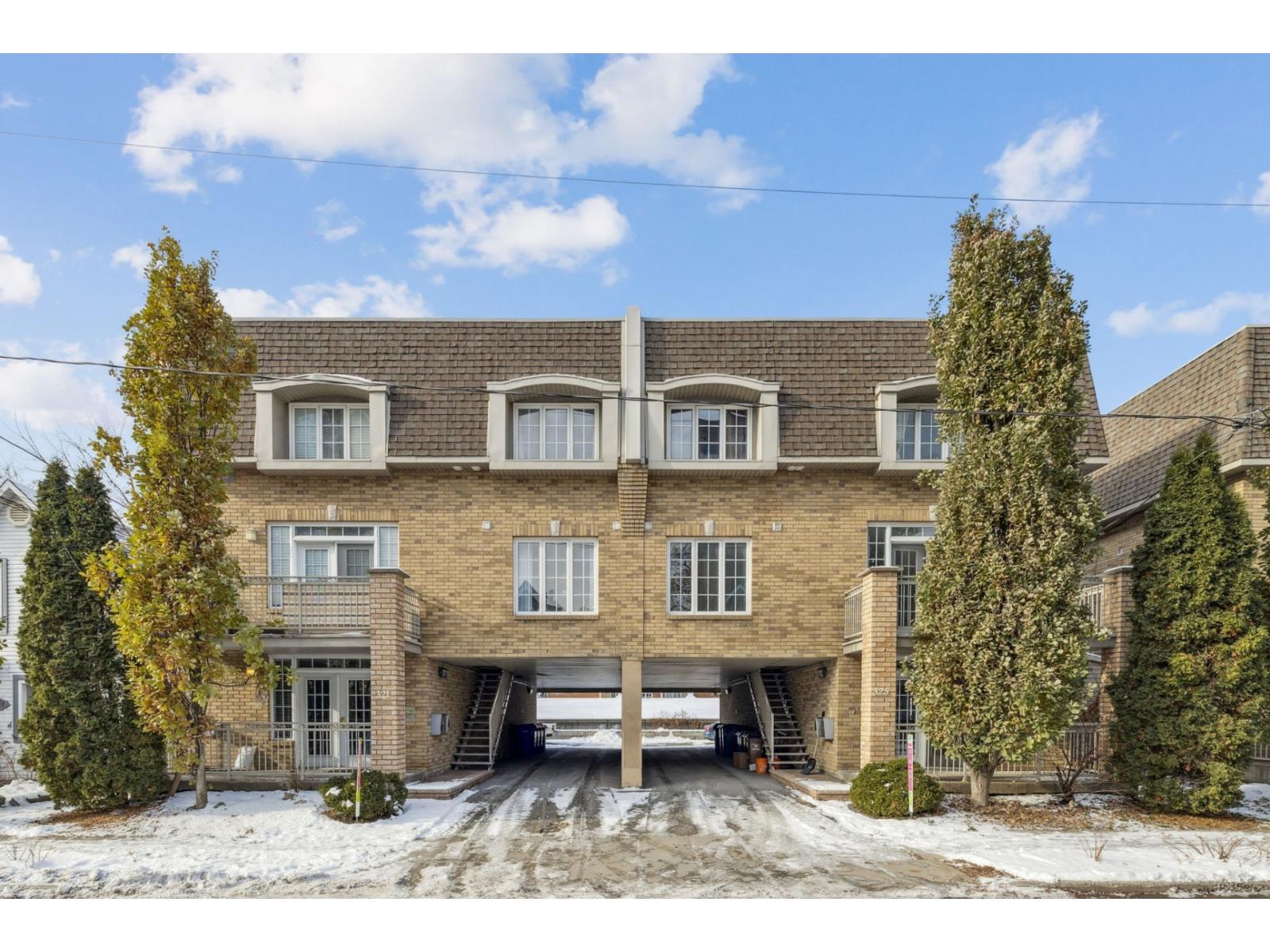 A large house with a garage and a driveway covered in snow.