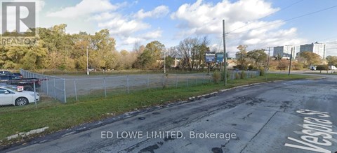 A street view with a sign that says "ED LOWE LIMITED, Brokerage".
