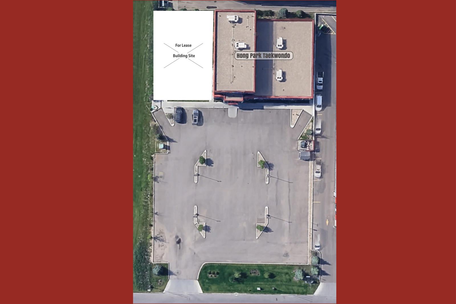 A parking lot with a white sign that says For Lease Building Site.