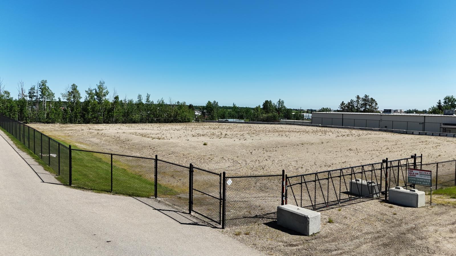 A fenced area with a gate and a signboard.