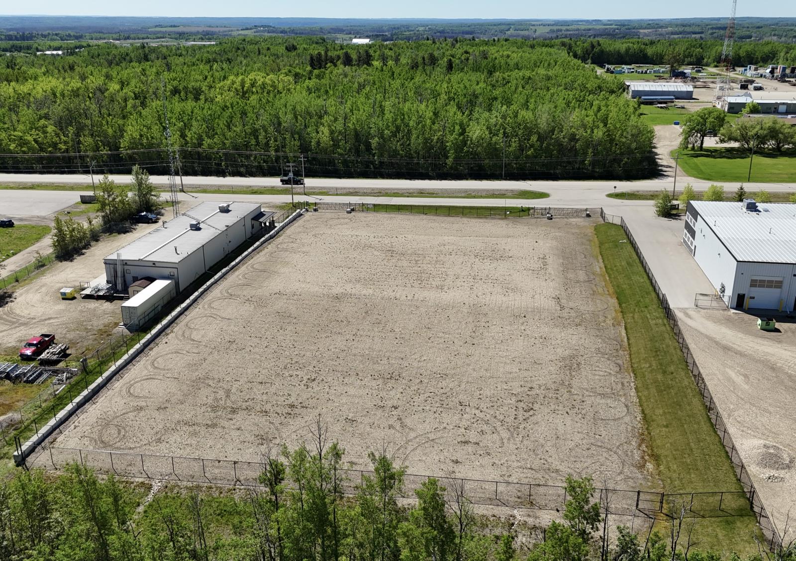 An aerial view of a large, empty parking lot surrounded by buildings and trees.