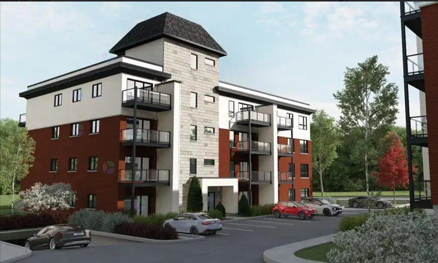 A modern apartment building with a parking lot in front.