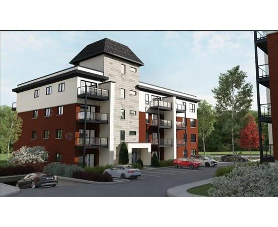 A modern apartment building with a parking lot in front.