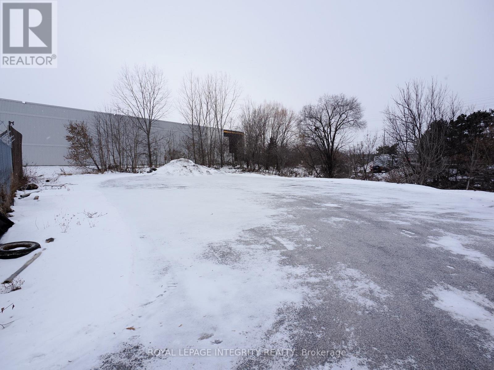 A snow-covered ground with a building in the background.