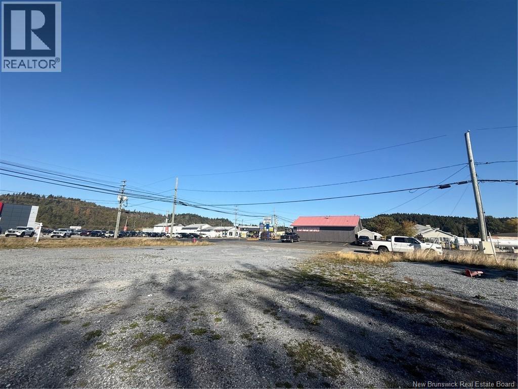 A gravel lot with a building in the background and a sign that says REALTOR.