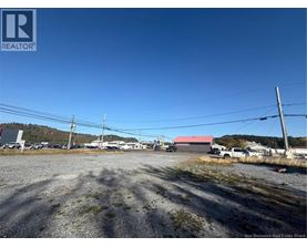 A gravel lot with a building in the background and a sign that says REALTOR.