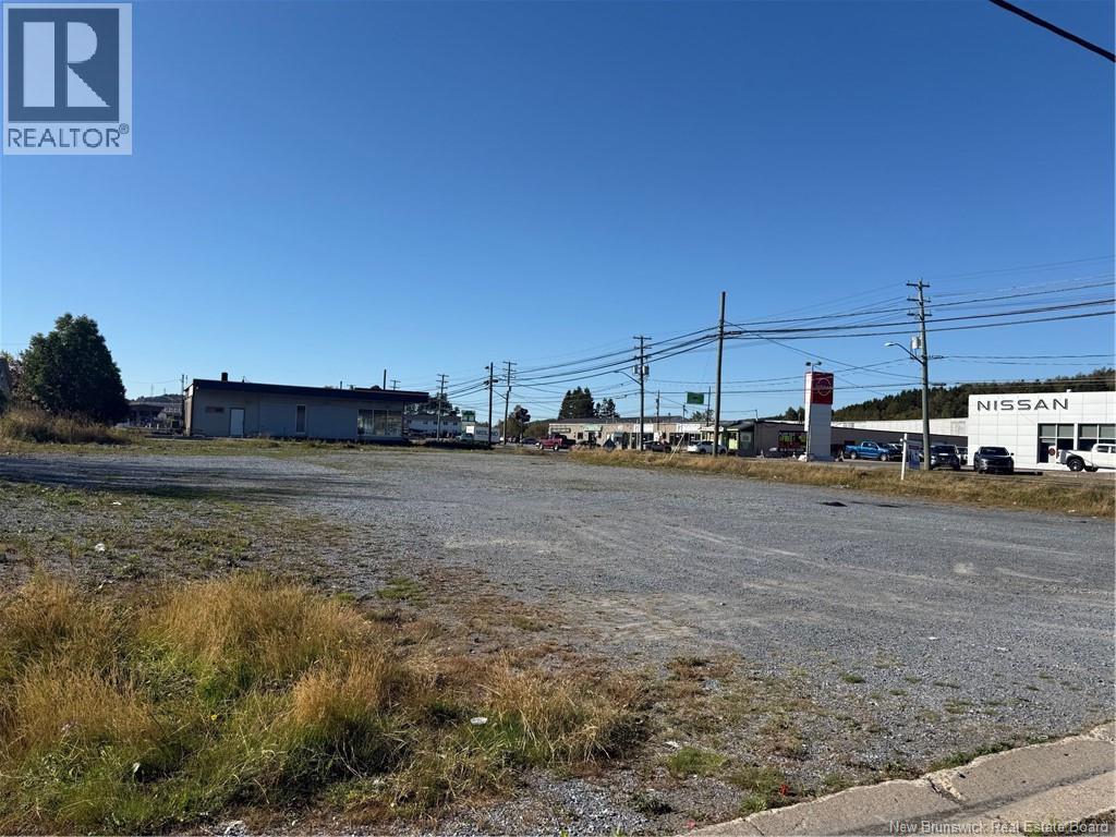 A Nissan dealership with a gravel lot in front.