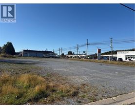 A Nissan dealership with a gravel lot in front.