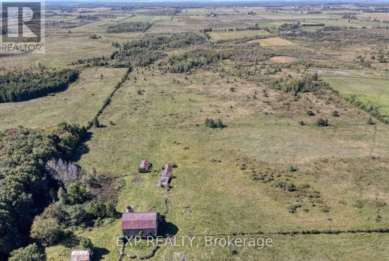 A rural landscape with a few buildings and a text overlay.