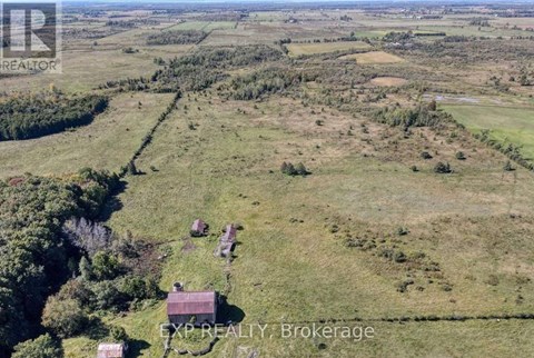 A rural landscape with a few buildings and a text overlay.