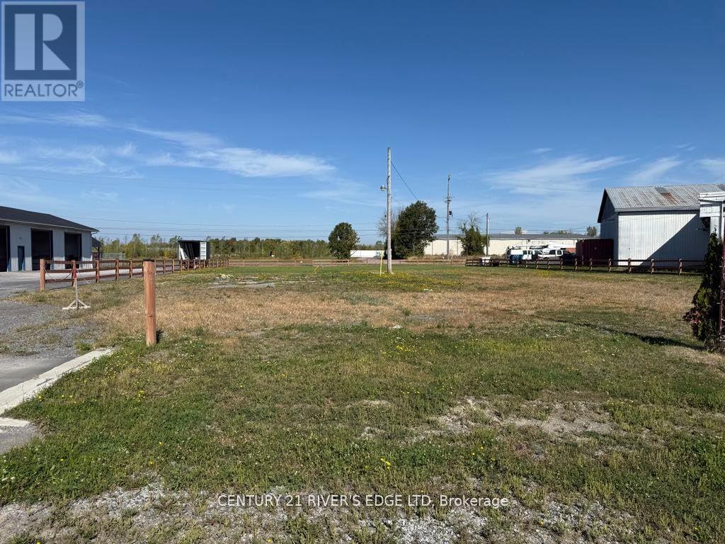 A grassy field with a building and a telephone pole in the background.