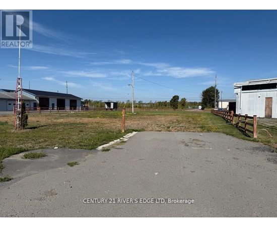 A realtor photo of a property with a building and a fence.