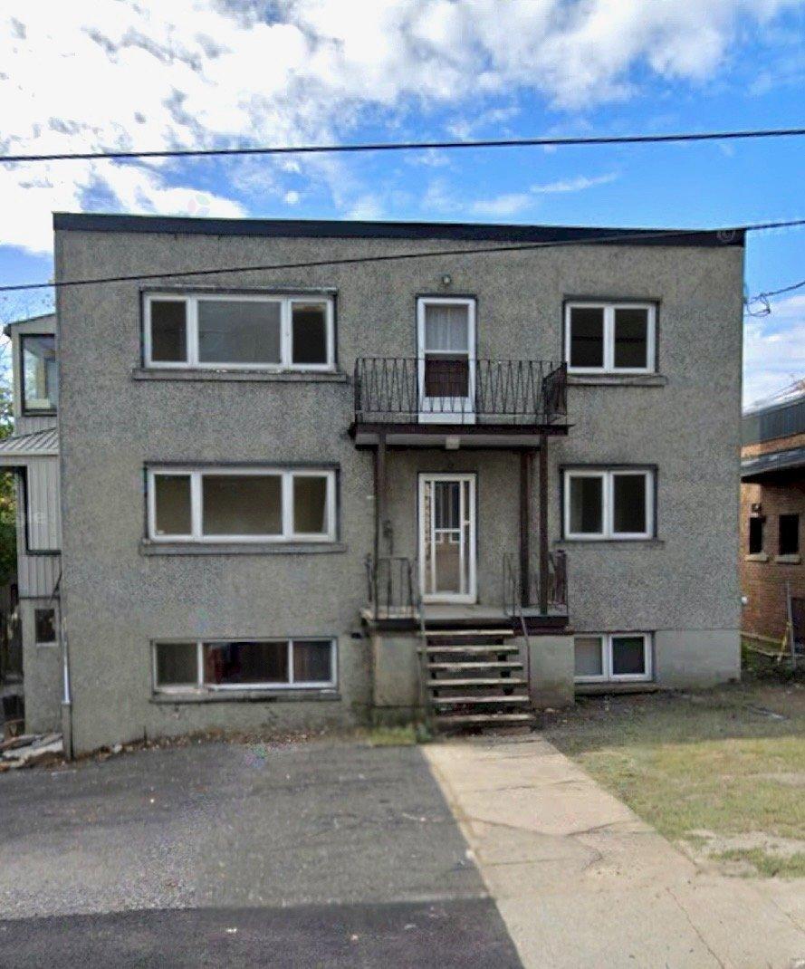 A grey building with a balcony on the second floor.