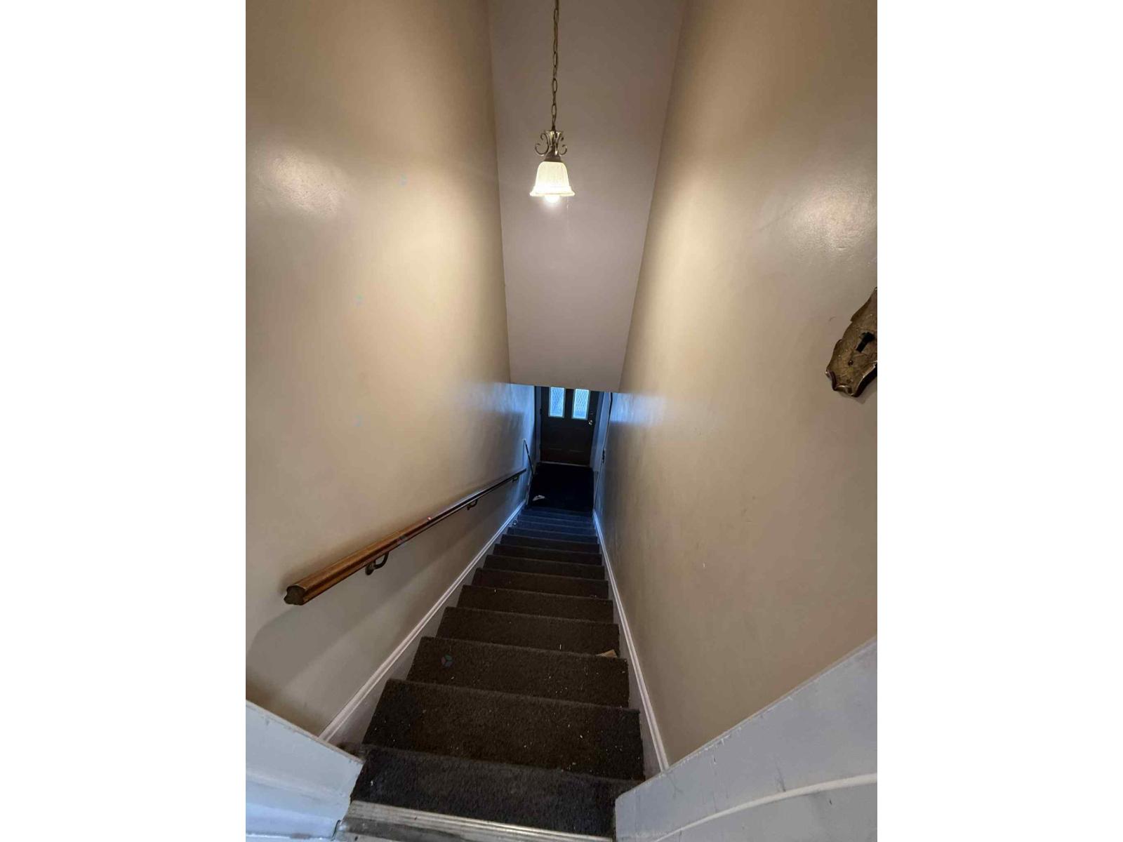 A staircase with a light hanging from the ceiling.