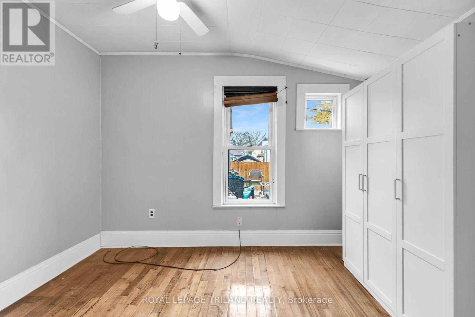 A room with a window and a fan on the ceiling.