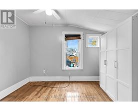 A room with a window and a fan on the ceiling.