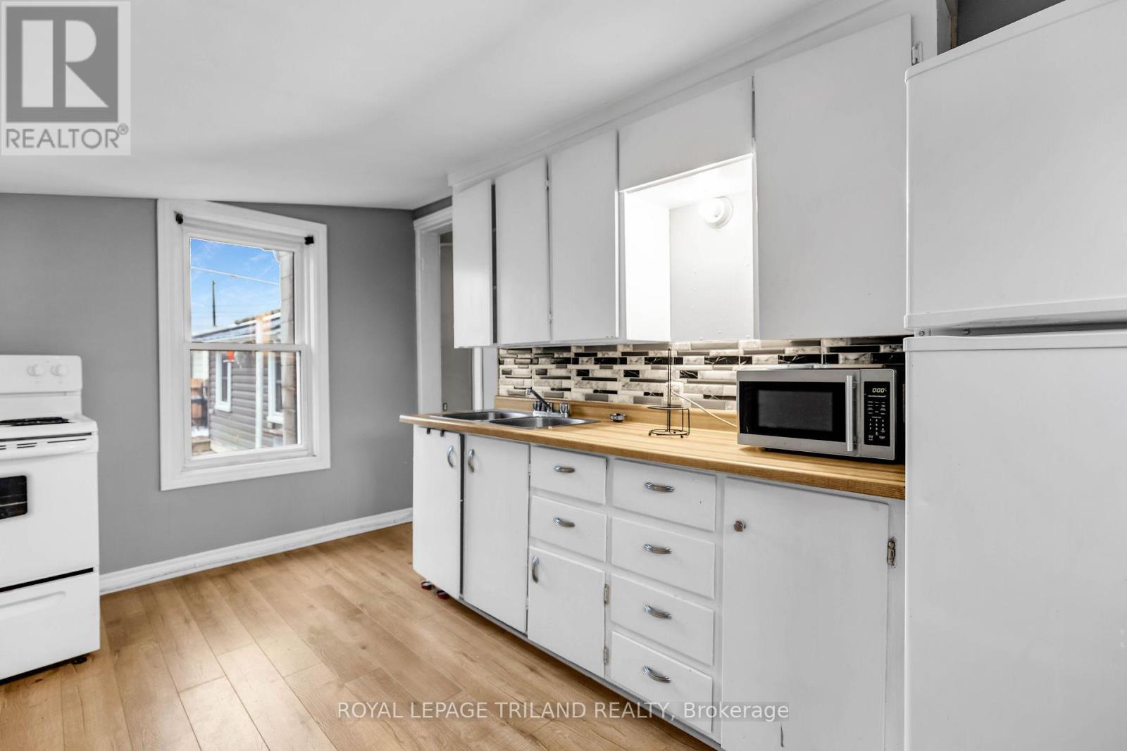 A kitchen with white cabinets and a wooden countertop.
