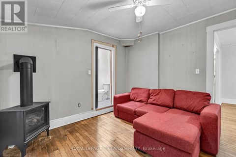 A living room with a red couch and a wood burning stove.