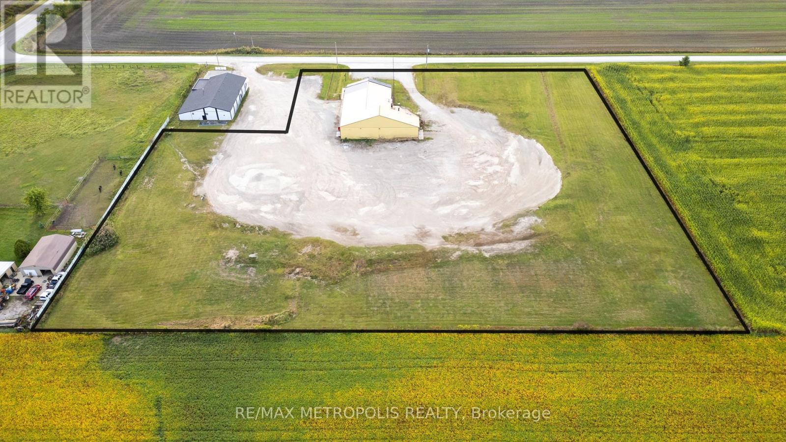 A property listing image shows a large open field with a small house and a shed.