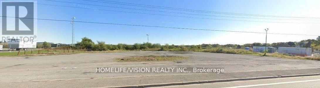 A sign for HomeLife/Vision Realty Inc. in Brokerage is displayed in an empty parking lot.