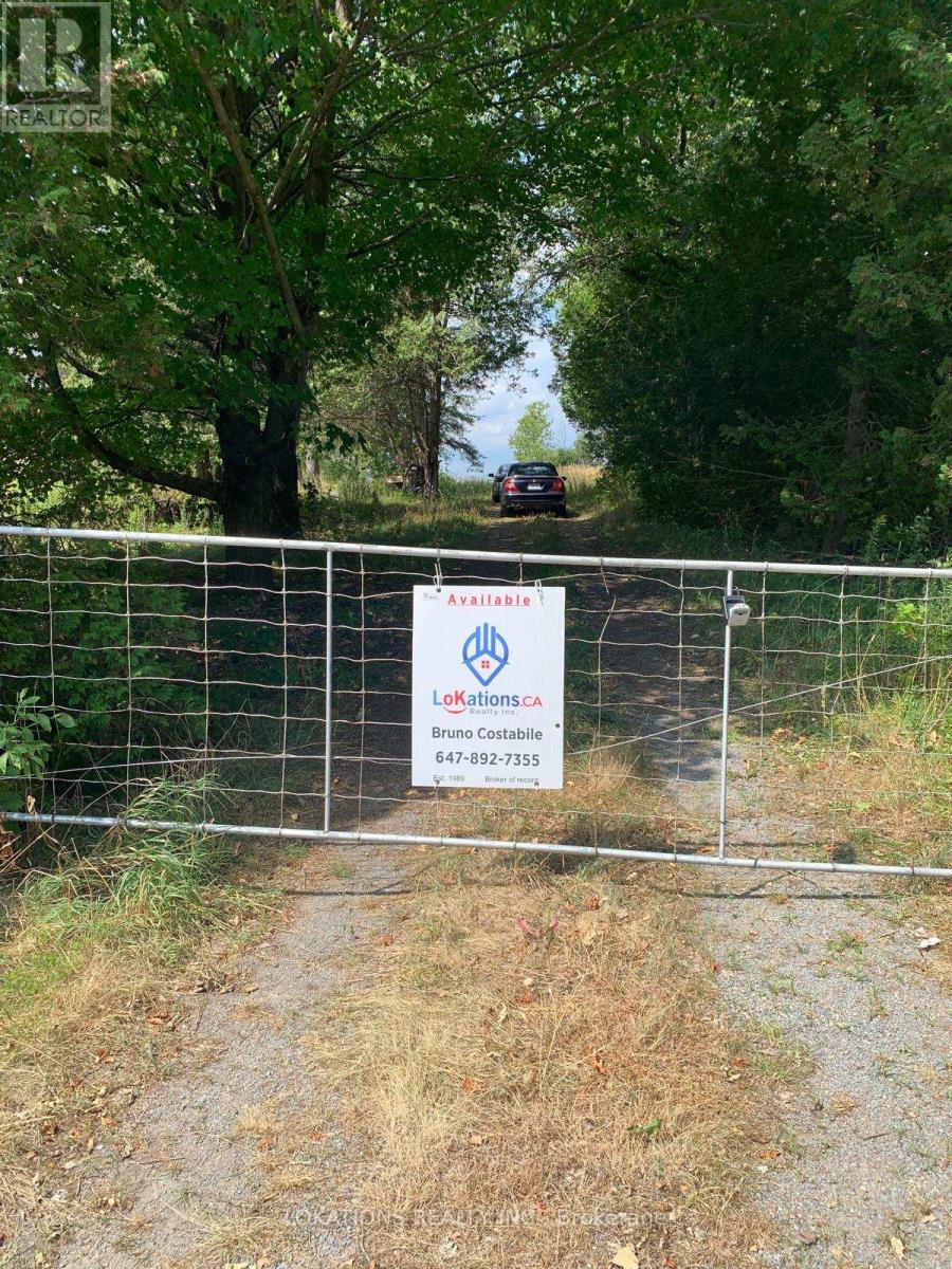 A sign for Avaxilaria is posted on a fence in front of a wooded area.