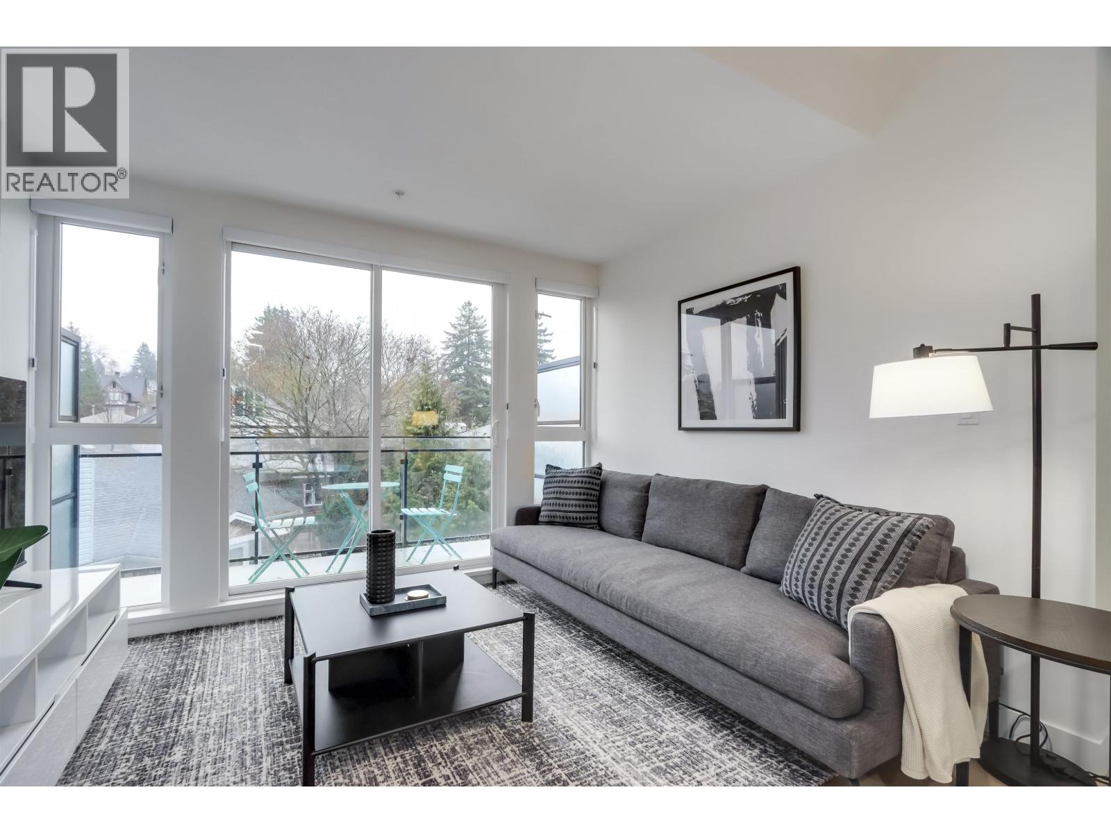 A living room with a grey couch and a black coffee table.