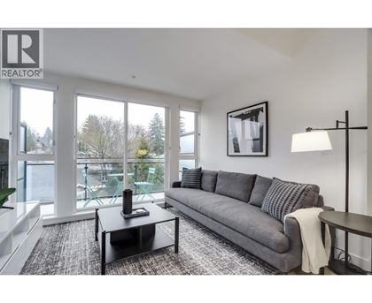 A living room with a grey couch and a black coffee table.
