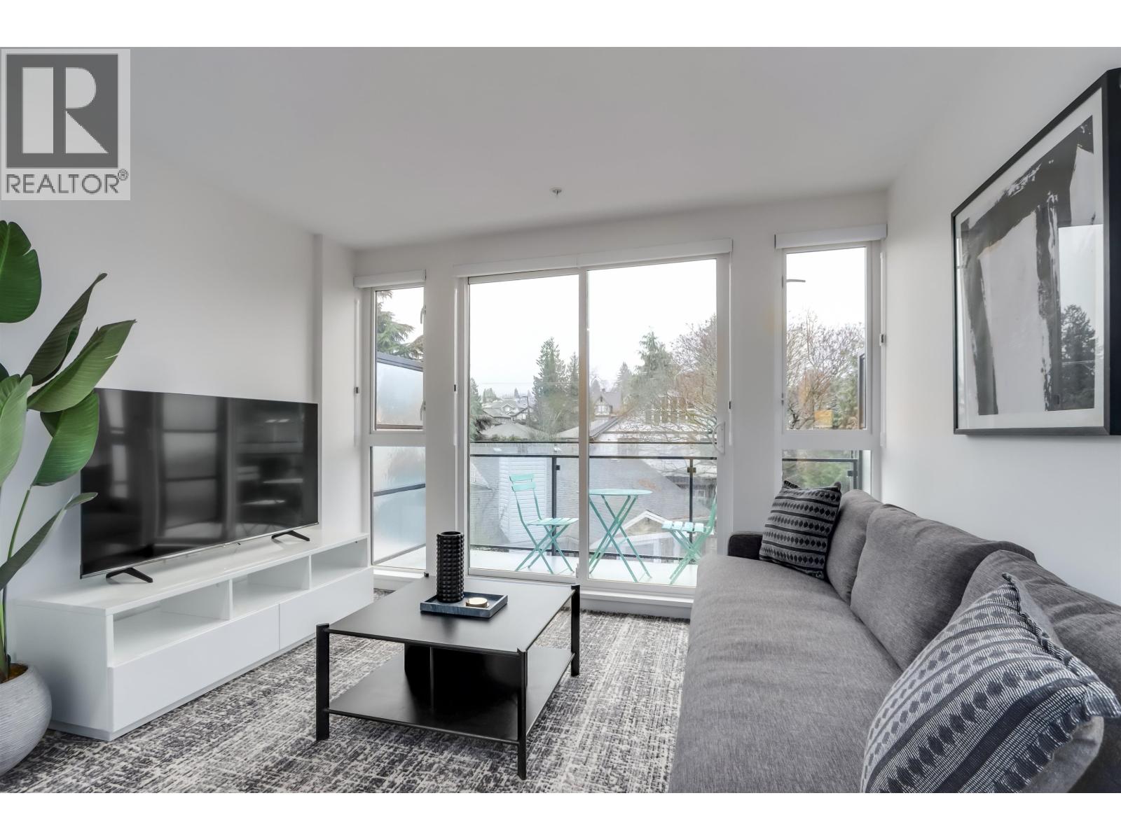 A living room with a grey couch and a black coffee table.