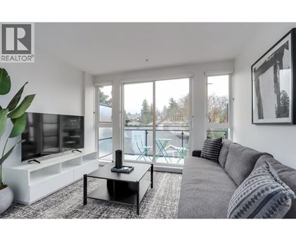 A living room with a grey couch and a black coffee table.