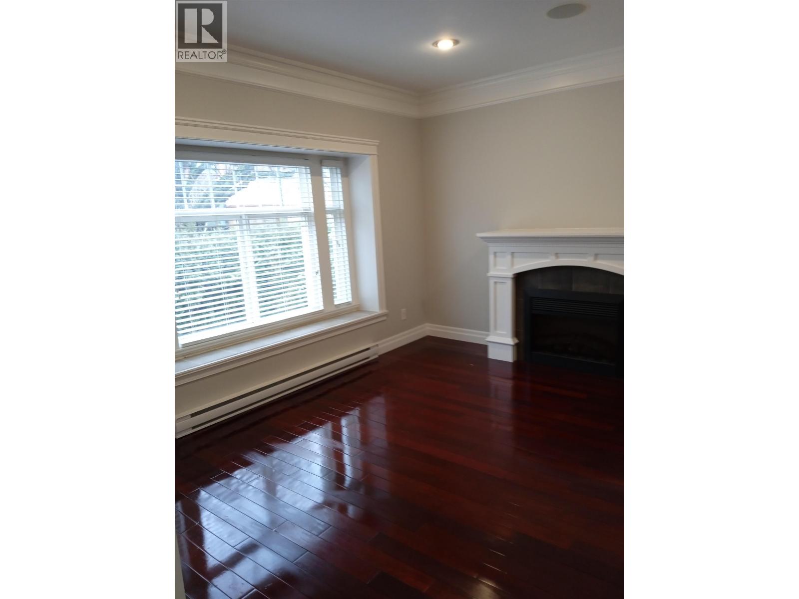 A room with a fireplace and wood flooring.