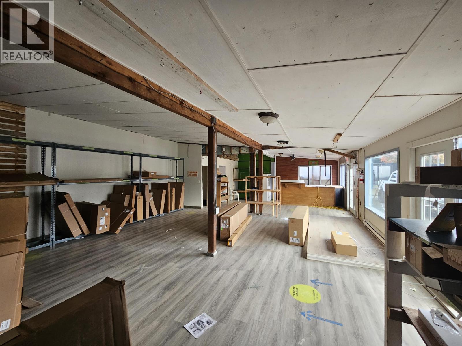 A room with wooden floors and a lot of boxes and furniture.
