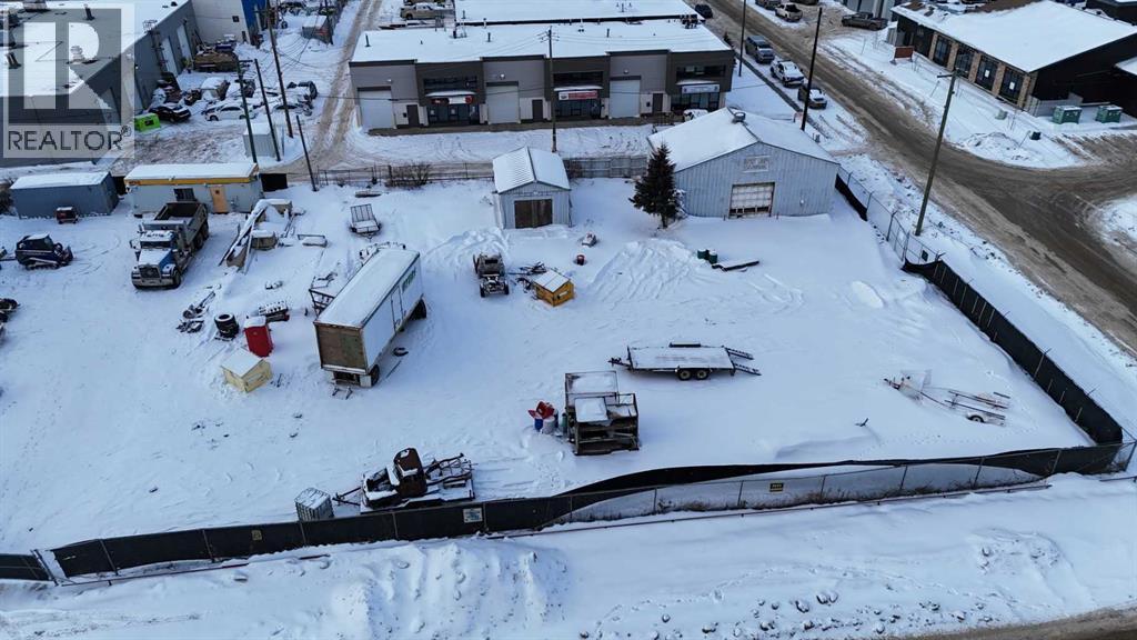 A snowy parking lot with a REALTOR sign in the background.