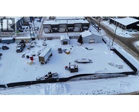 A snowy parking lot with a REALTOR sign in the background.