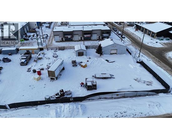 A snowy parking lot with a REALTOR sign in the background.