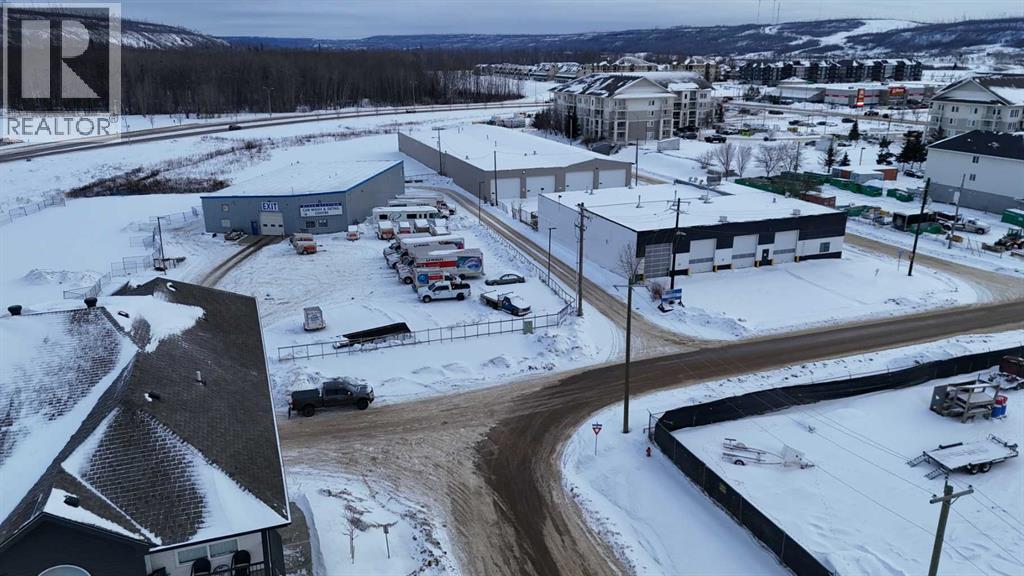 A snowy landscape with a building and cars parked outside.