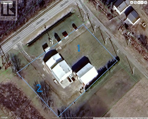 A satellite image shows a property with a large building and a smaller structure, surrounded by a fence.