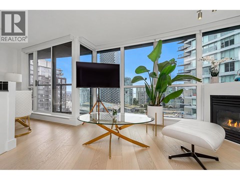 A living room with a glass table and a white sofa.