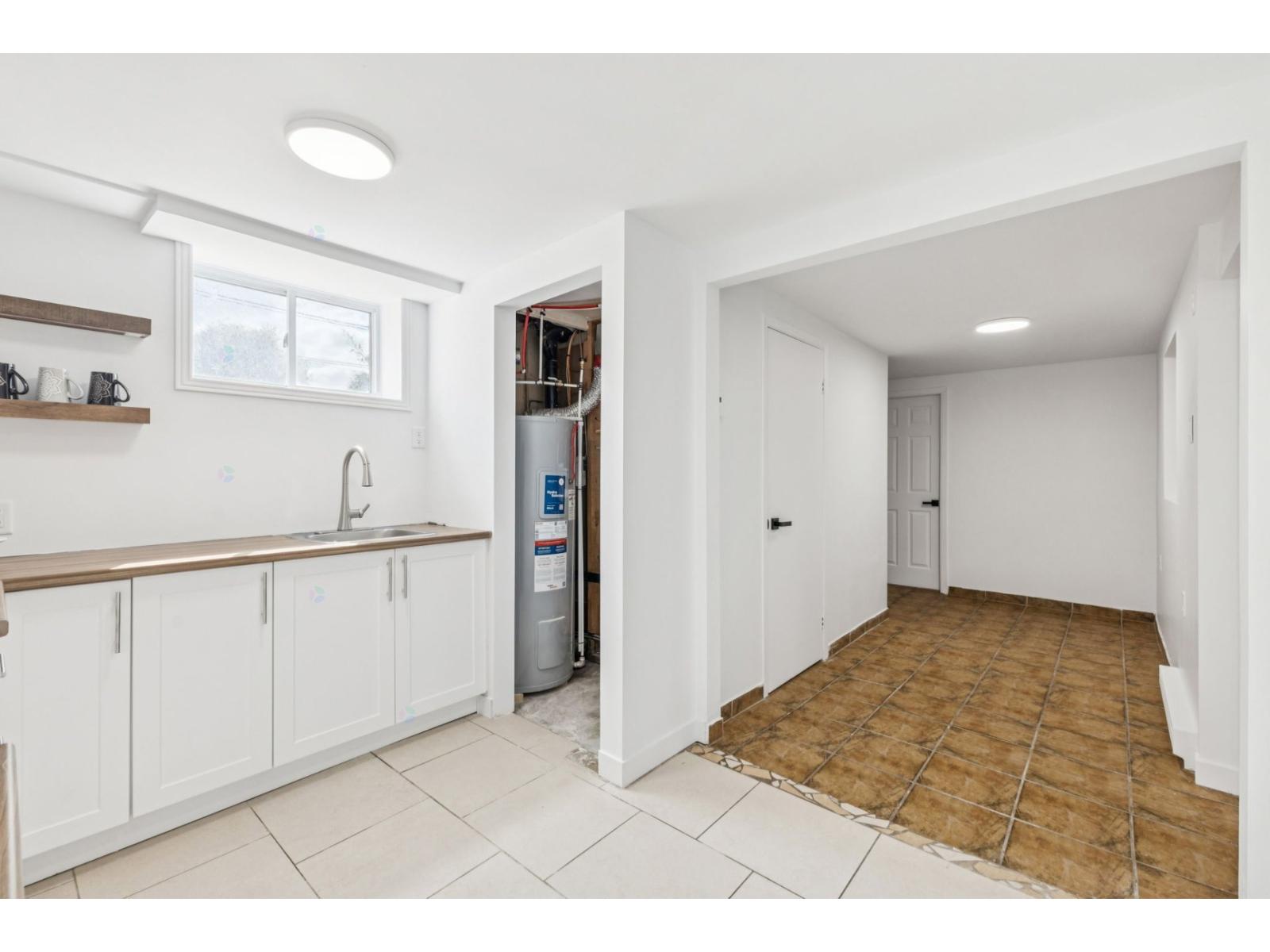 A kitchen with white cabinets and a refrigerator.