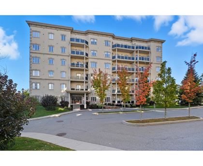 A large beige apartment building with a sign that reads "Monroe 11 154" in front of it.